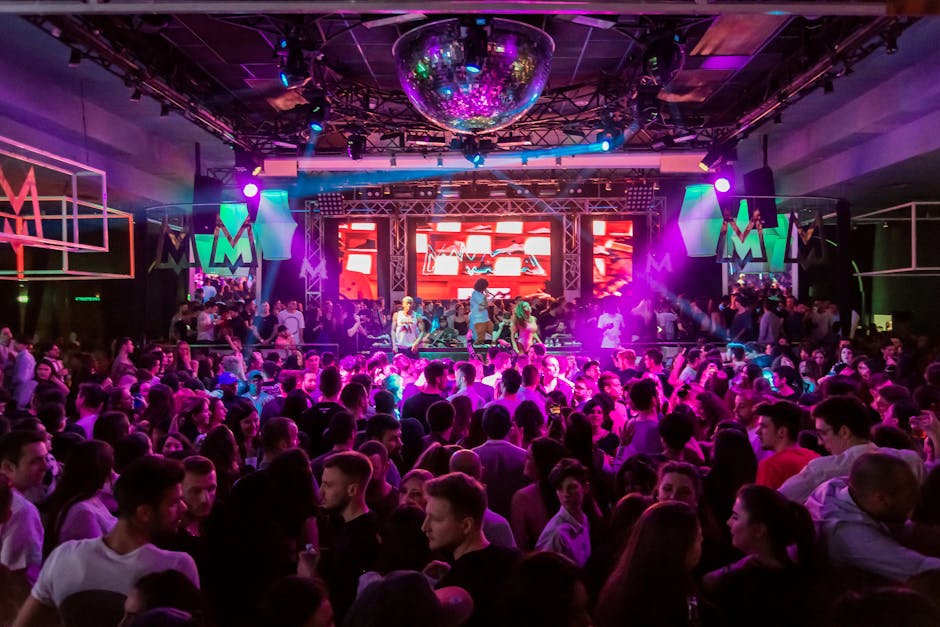 Dynamic crowd at a lively nightclub in Mantua, Italy, with vibrant lights and energetic atmosphere