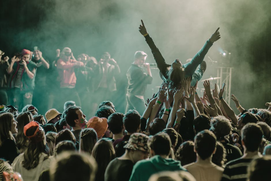 A vibrant concert scene with a crowd surfer and lively audience members enjoying a live performance